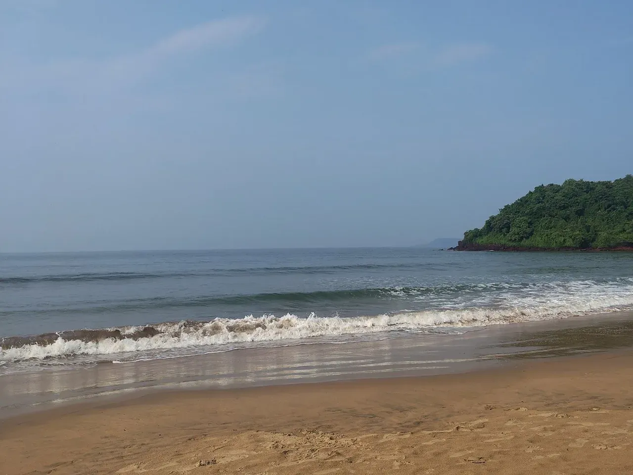 Quiet beach with a green headland