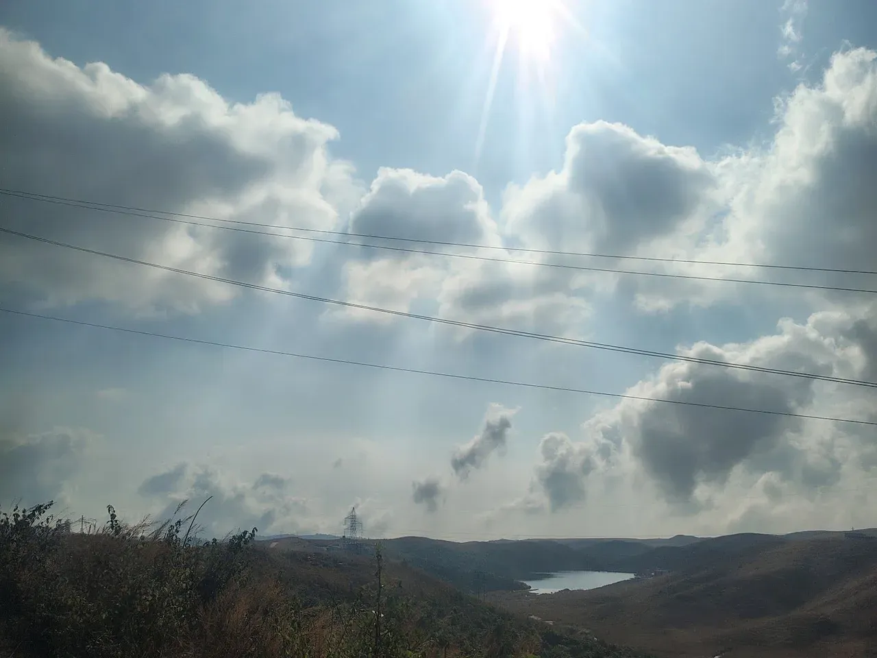 Sun breaking through clouds over the hills
